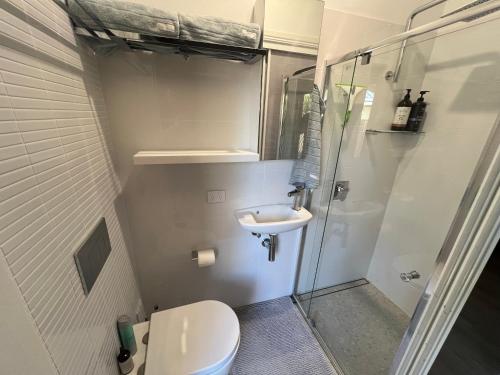 a small bathroom with a toilet and a sink at Lakeside Riverfront Yamba 1-2 Small Pet Friendly in Yamba