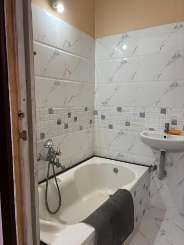 a bathroom with a bath tub and a sink at Satya Residency in Kākināda