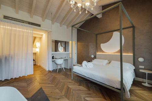 a bedroom with a canopy bed and a desk at Hotel Bigio in San Pellegrino Terme