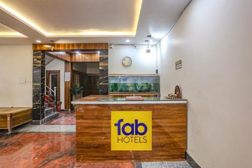 a hotel lobby with a sign on a counter at FabHotel Imperail House in Prayagraj