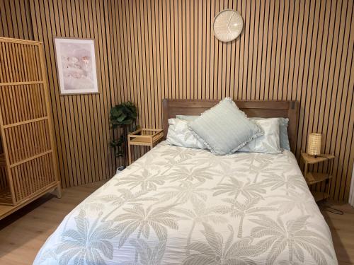 a bedroom with a bed and a clock on the wall at Lakeside Riverfront Yamba 1-2 Small Pet Friendly in Yamba