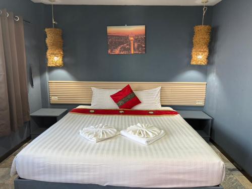 a bedroom with a large white bed with two white shoes at Istanbul Boutique Hotel in Patong Beach