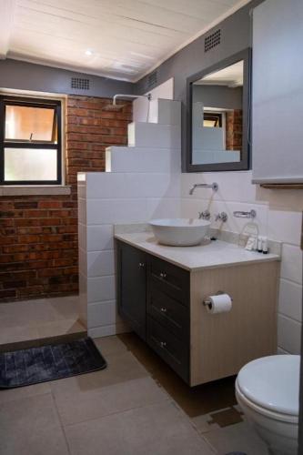 a bathroom with a sink and a toilet at 133onFifth in Umtali