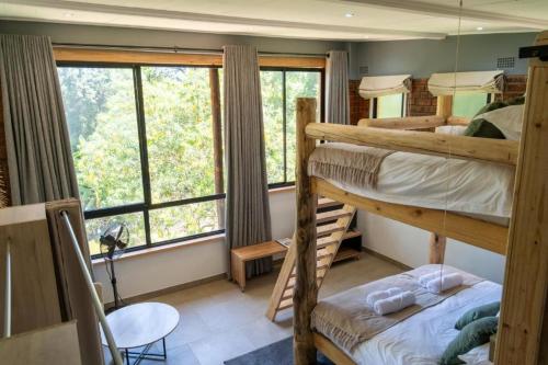 a bedroom with two bunk beds and a table and a chair at 133onFifth in Umtali