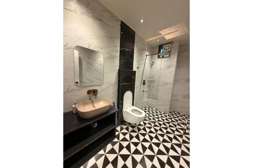 a bathroom with a sink and a toilet and a shower at The Shivanta Inn in Ābu Road