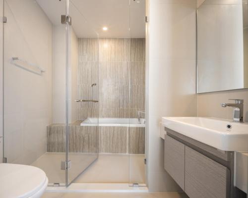 a bathroom with a shower and a sink and a toilet at Hampton Sriracha in Si Racha