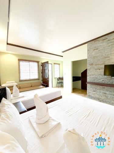 a large bedroom with a large bed and a fireplace at Palmas Del Mar Resort Bacolod in Bacolod