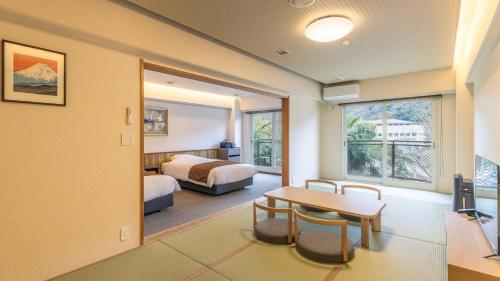 ein Hotelzimmer mit Schlafzimmer, Bett und Tisch in der Unterkunft HOTEL nehako in Hakone