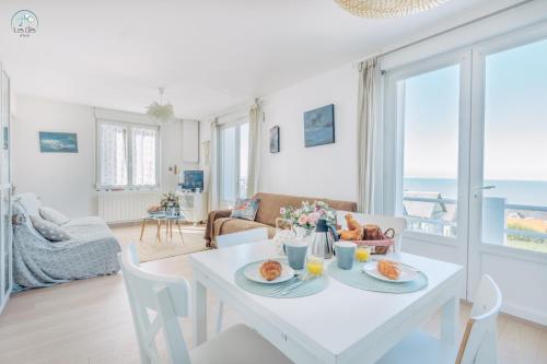 a white living room with a table with food on it at 11- Clapotis de l'Ô - Balcon sur la Mer - Parking Privé in Ault