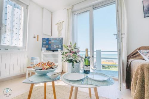a living room with a table and two chairs at 11- Clapotis de l'Ô - Balcon sur la Mer - Parking Privé in Ault