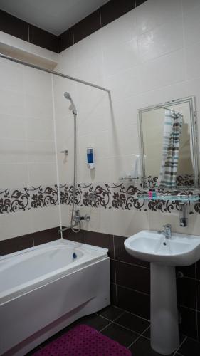 a bathroom with a bath tub and a sink at Hepci Hotel Istaravshan in Ŭroteppa