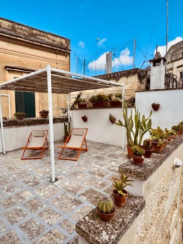 a patio with two chairs and a canopy on a building at Artas la tua casa indipendente a Lecce in Lecce
