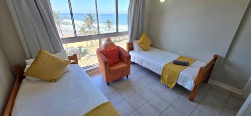 a room with two beds and a chair and a window at Seabrook 404 - Sleeps 8 in Margate