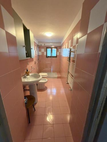 a bathroom with two toilets and a sink and a tub at L' Èef Cascina in San Cassiano