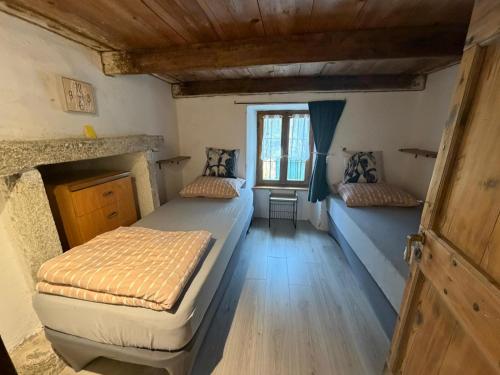 a bedroom with two beds and a window at L' Èef Cascina in San Cassiano