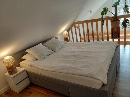 a bed in a room with a staircase at Domek Kaprys Piatkowa in Piątkowa