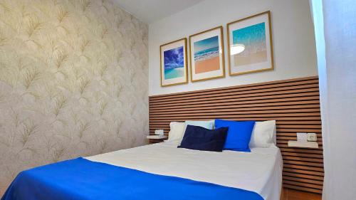 a bedroom with a bed with blue and white pillows at Apartamento Chay in Málaga
