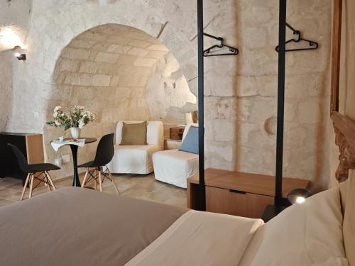 a hotel room with a bed and a table with chairs at Dimore dei Mercanti in Matera