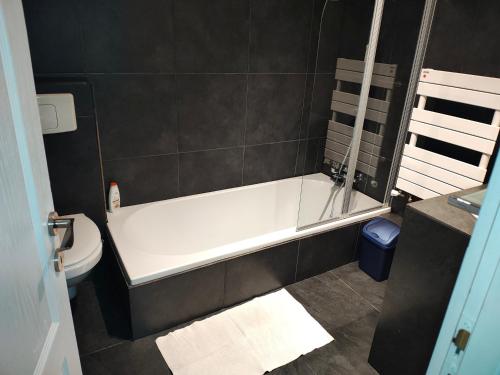 a bathroom with a white bath tub and a toilet at Panaghie in Hangul