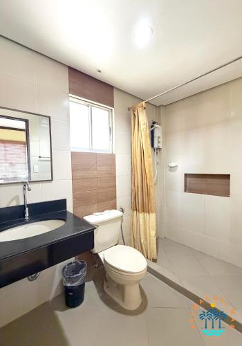 a bathroom with a toilet and a sink at Palmas Del Mar Resort Bacolod in Bacolod
