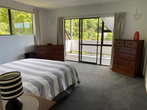 a bedroom with a bed and a large window at Harbour View on Buller in Picton