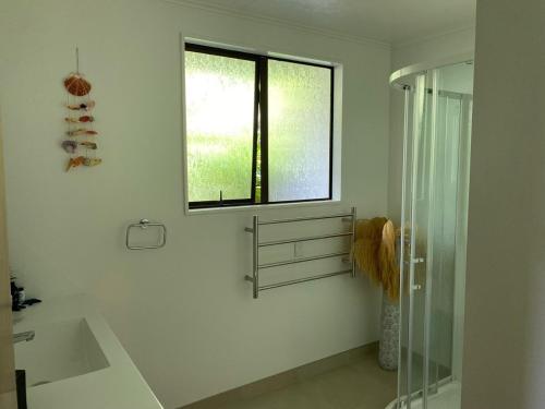 a bathroom with a shower and a sink and a window at Harbour View on Buller in Picton