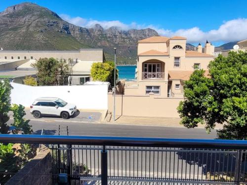 a white car parked in front of a house with mountains at Leehaven in Hout Bay