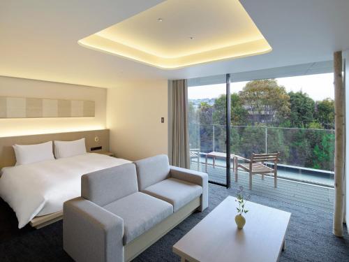 a hotel room with a bed and a couch at HOTEL FORK & KNIFE Miyajima in Miyajima