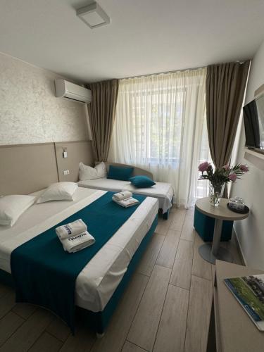 ein Hotelzimmer mit zwei Betten und einem Tisch in der Unterkunft Hotel Delfin in Mamaia
