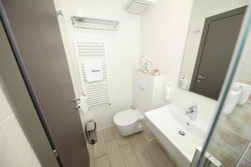 ein weißes Badezimmer mit Toilette und Waschbecken in der Unterkunft Hotel Delfin in Mamaia