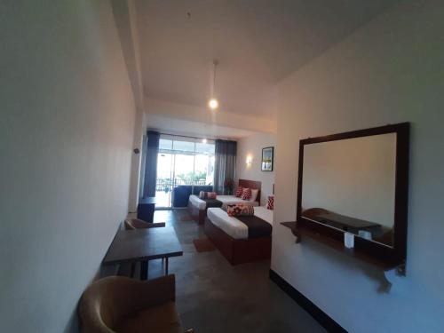 a living room with a mirror and a couch at Green Villa Ella in Ella