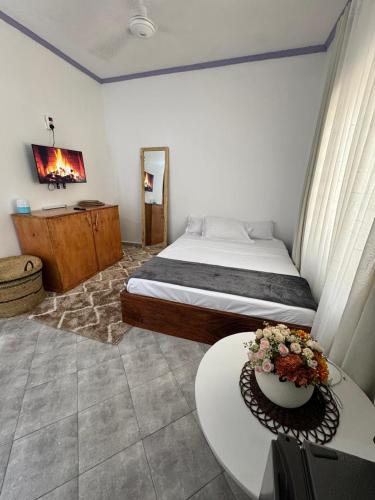 a bedroom with a bed and a table with flowers on it at nova nest in Watamu