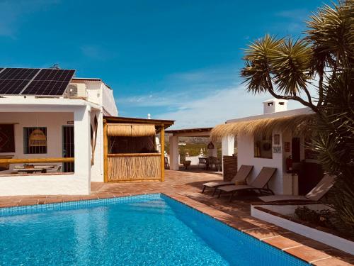 a villa with a swimming pool next to a house at Casa Bambú Boutique Studios Andalusië with pool and Mountain Views in Vélez-Málaga