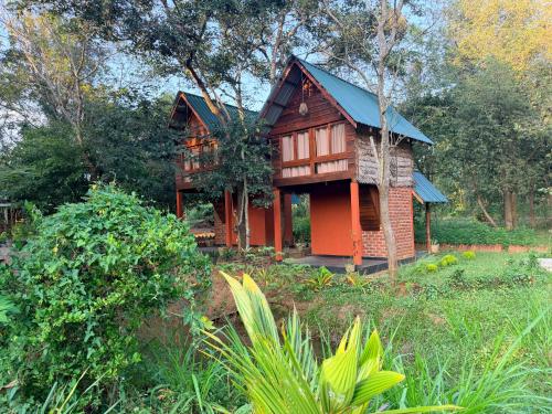 a small wooden house with a blue roof at Mango Tree Villa in Sigiriya