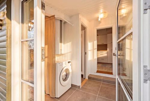 a laundry room with a washer and dryer at Sommerhusidyl med vildmarksbad, strand og udebruser in Jægerspris