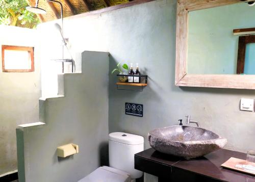 a bathroom with a sink and a toilet at Pedidi Penida Hostel in Nusa Penida