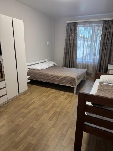 a bedroom with two beds and a window at Надія in Khlibodarske