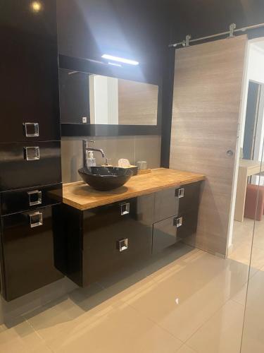 a bathroom with a black sink and a mirror at Appartement jardin in Le Cannet