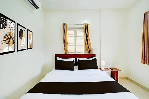 a bedroom with a bed and a window at Hotel Safko Suites in Bangalore