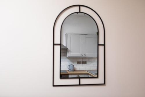 an archway mirror in a kitchen with a sink at Camden St Accommodation in Derby