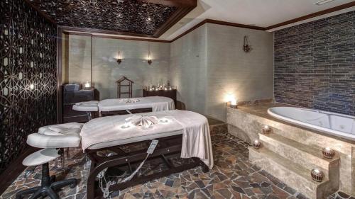 a bathroom with two massage tables and a bath tub at Angel's Marmaris Hotel in Turgut