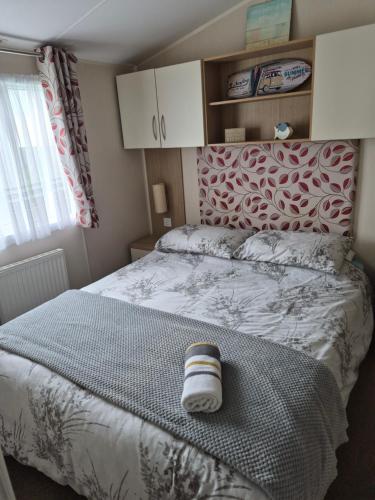 a bedroom with a bed with a towel on it at Bude Caravan Caromax - Families and Couples Only in Bude