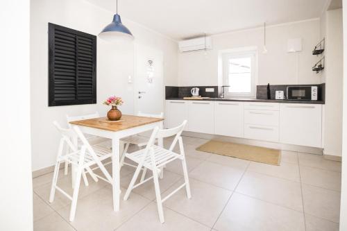 a kitchen with white cabinets and a table and chairs at Hisa Bubi in Tolmin