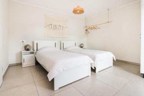 two beds in a white bedroom with white walls at Hisa Bubi in Tolmin