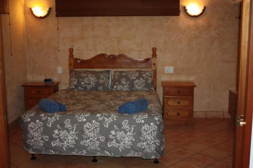 a bedroom with a bed and a wooden headboard at Apartments at Blue Seas Resort in Broome