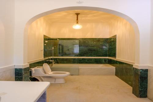a bathroom with a toilet and a bath tub at The Bagheera Heritage, Jaipur in Jaipur