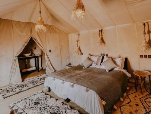 a bedroom with a bed in a tent at Lantern Luxury Camp in Merzouga