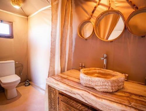 a bathroom with a wooden sink and mirrors at Lantern Luxury Camp in Merzouga