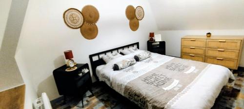 a bedroom with a bed and two clocks on the wall at Le Passage Secret in Saint-Omer
