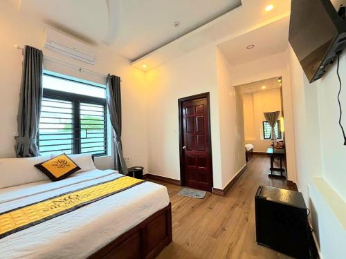 a bedroom with a bed and a flat screen tv at Nhi Quỳnh La Gi Hotel in Lagi